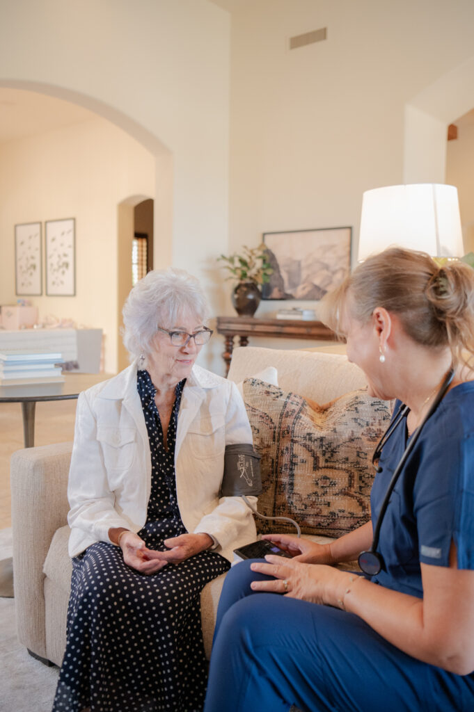 Caregiver and senior client having a conversation, both smiling and happy.