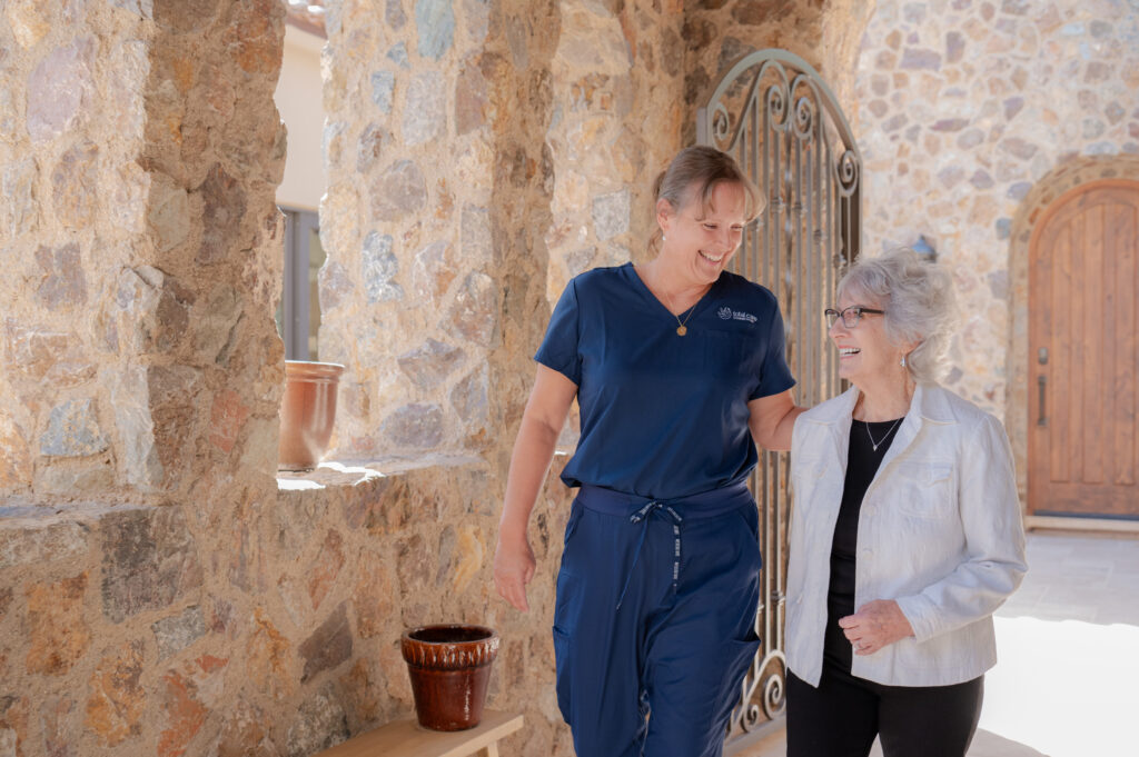 Caregiver walking with client at home.